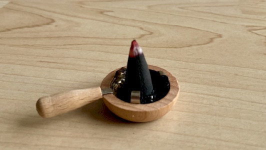 Foto einer Mini-Räucherpfanne mit glimmendem Räucherkerzchen